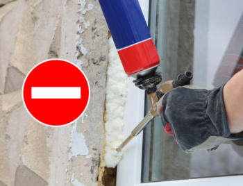 Worker's hand fix a window using polyurethane foam